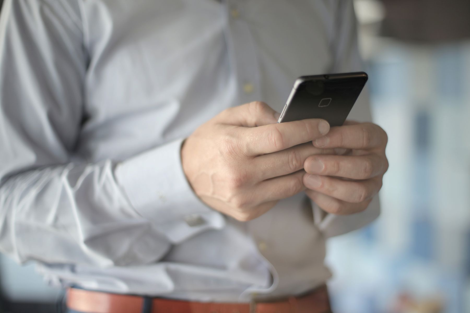 Close-up of a business professional using a smartphone with both hands