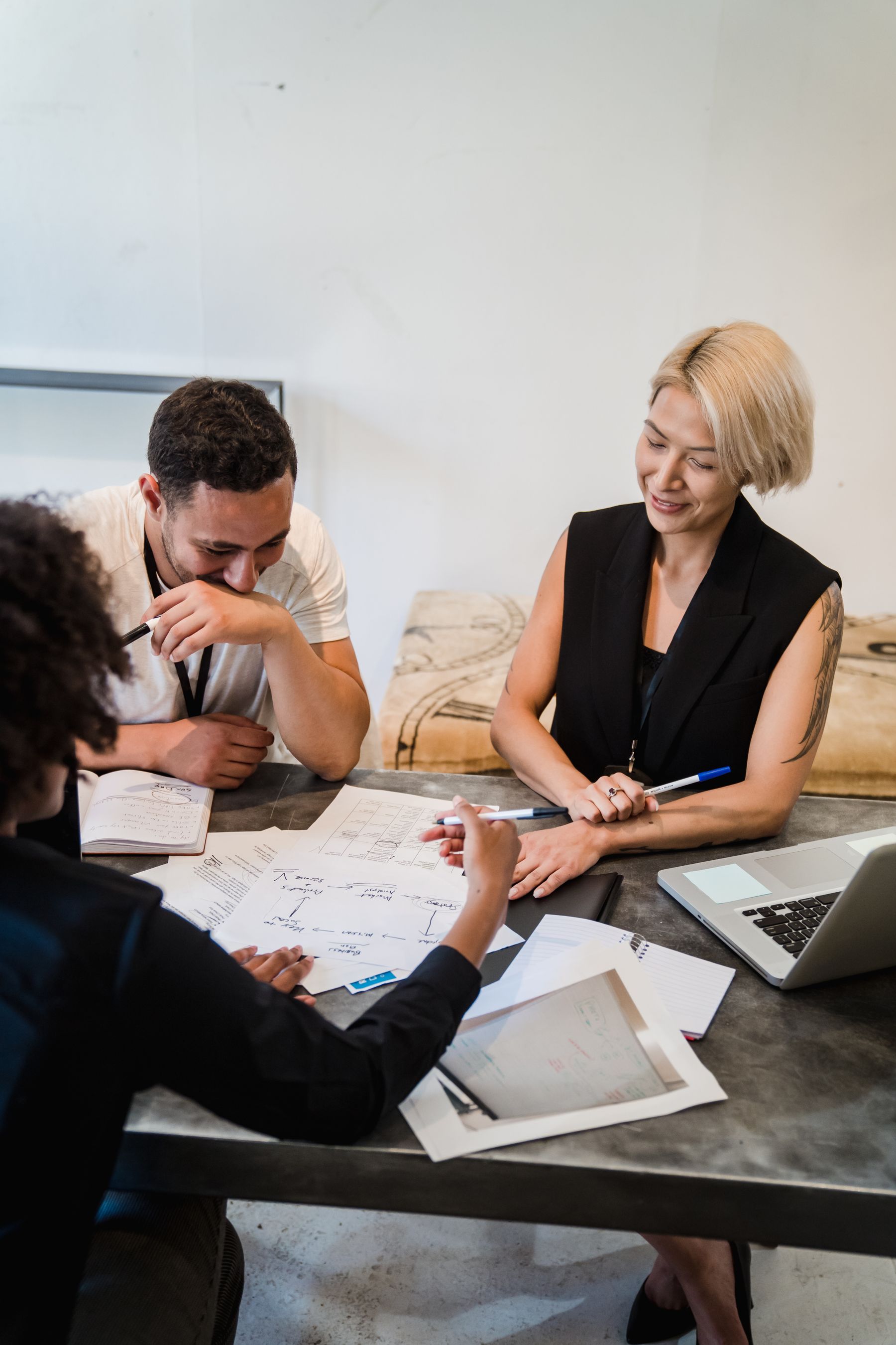 Colleagues planning a project together around a table with documents and a laptop